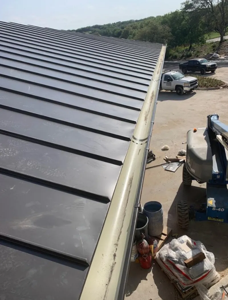 Standing seam panel and gutter detail on a metal roofing jobsite in Eatonton